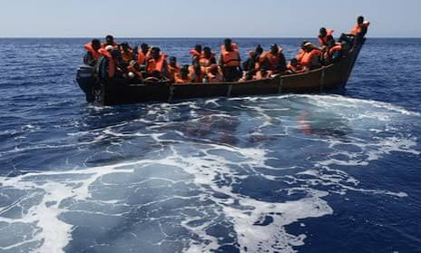 Alt Text: Migrant boat crossing the Mediterranean as sea arrivals to Europe decline but deaths increase
